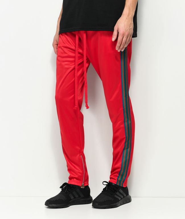 green track pants with red stripe