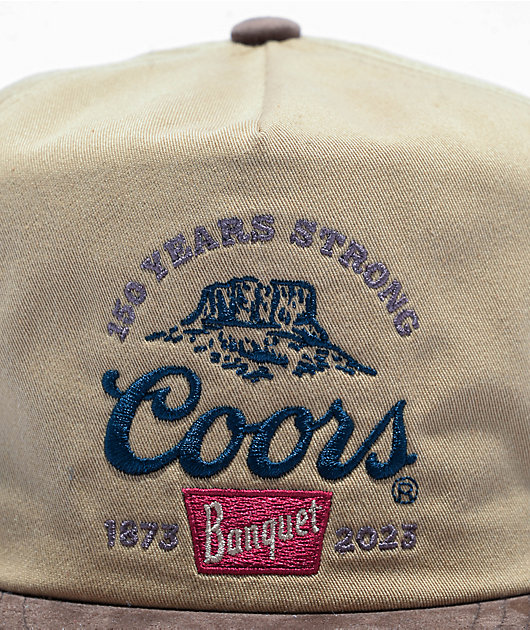 https://scene7.zumiez.com/is/image/zumiez/product_main_medium/Brixton-x-Coors-150th-Anniversary-Arch-Profile-Canvas-Brown-Snapback-Hat-_374211-alt1-US.jpg